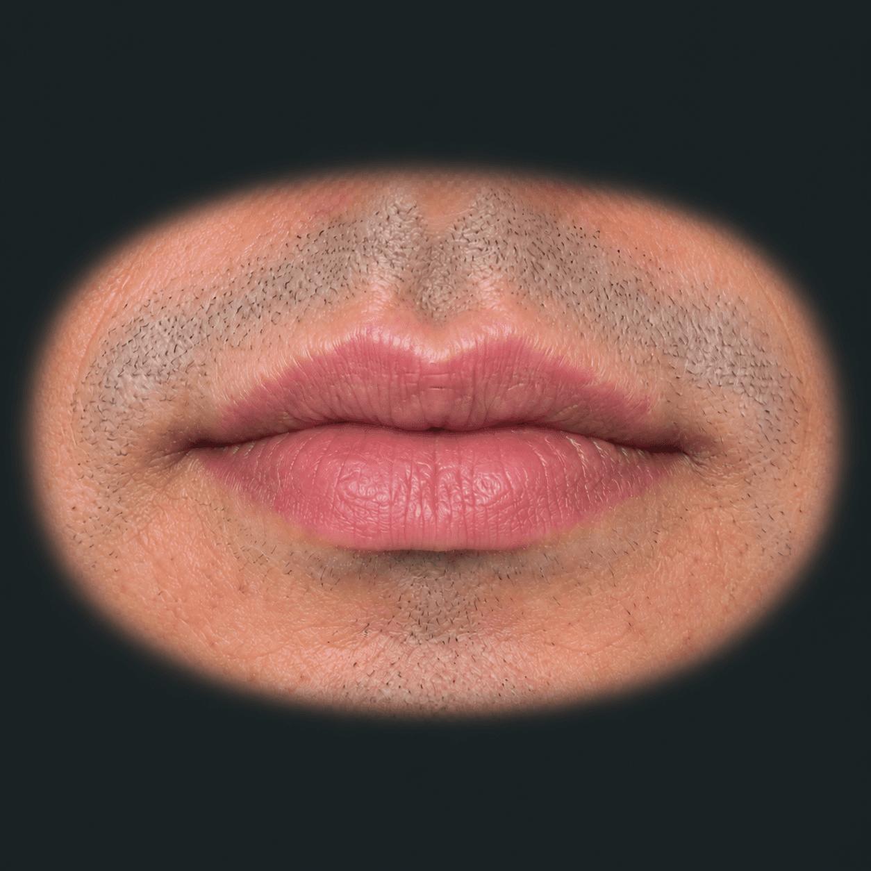 Labios del mismo hombre en expresión relajada, con su barba incipiente
